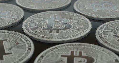 Macro close-up of silver cryptocurrency coins arranged on a dark surface